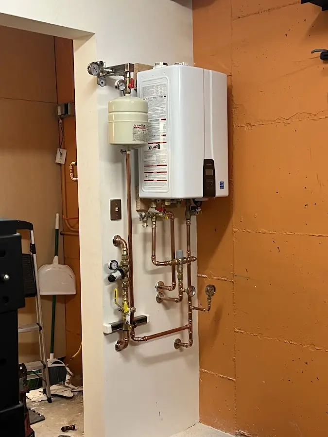 Plumbing technician inspecting water heater connections in Carmel-by-the-Sea